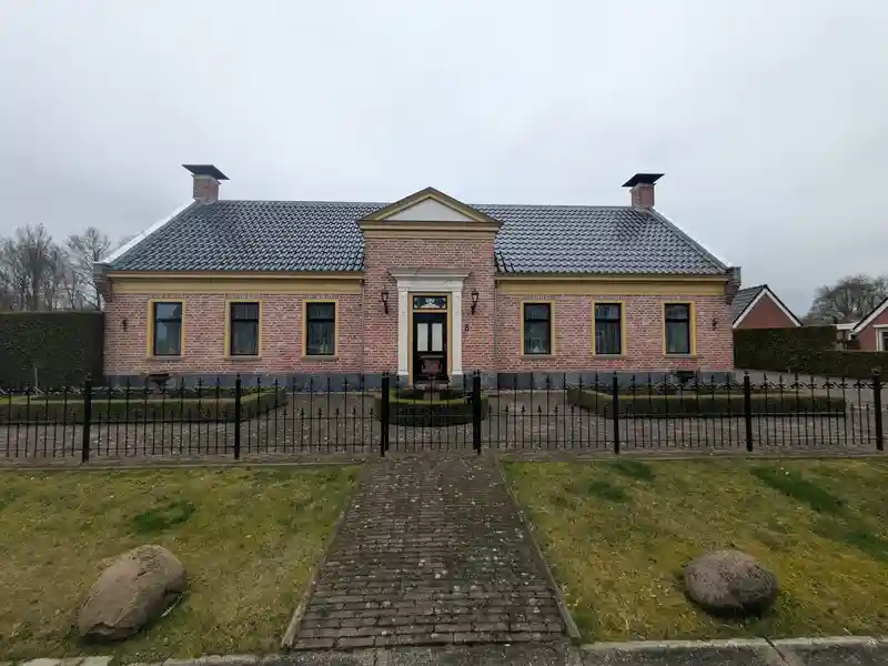 Vooraanzicht van een gebouw in Midwolda met nieuwe zinken deklijsten op de gevel